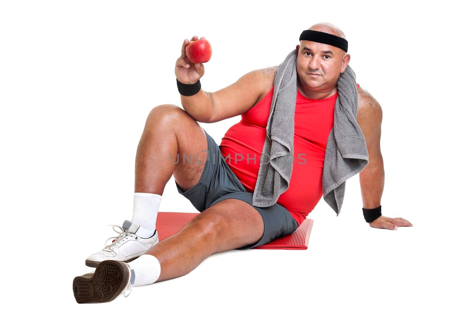 Large fitness man with an apple isolated in white