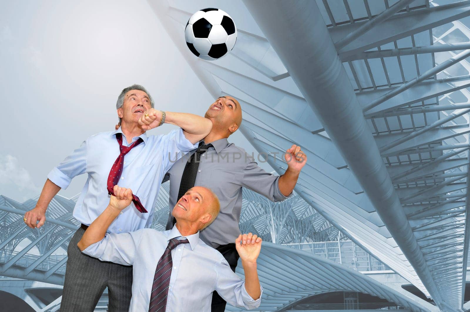 Businessmen playing soccer outdoors