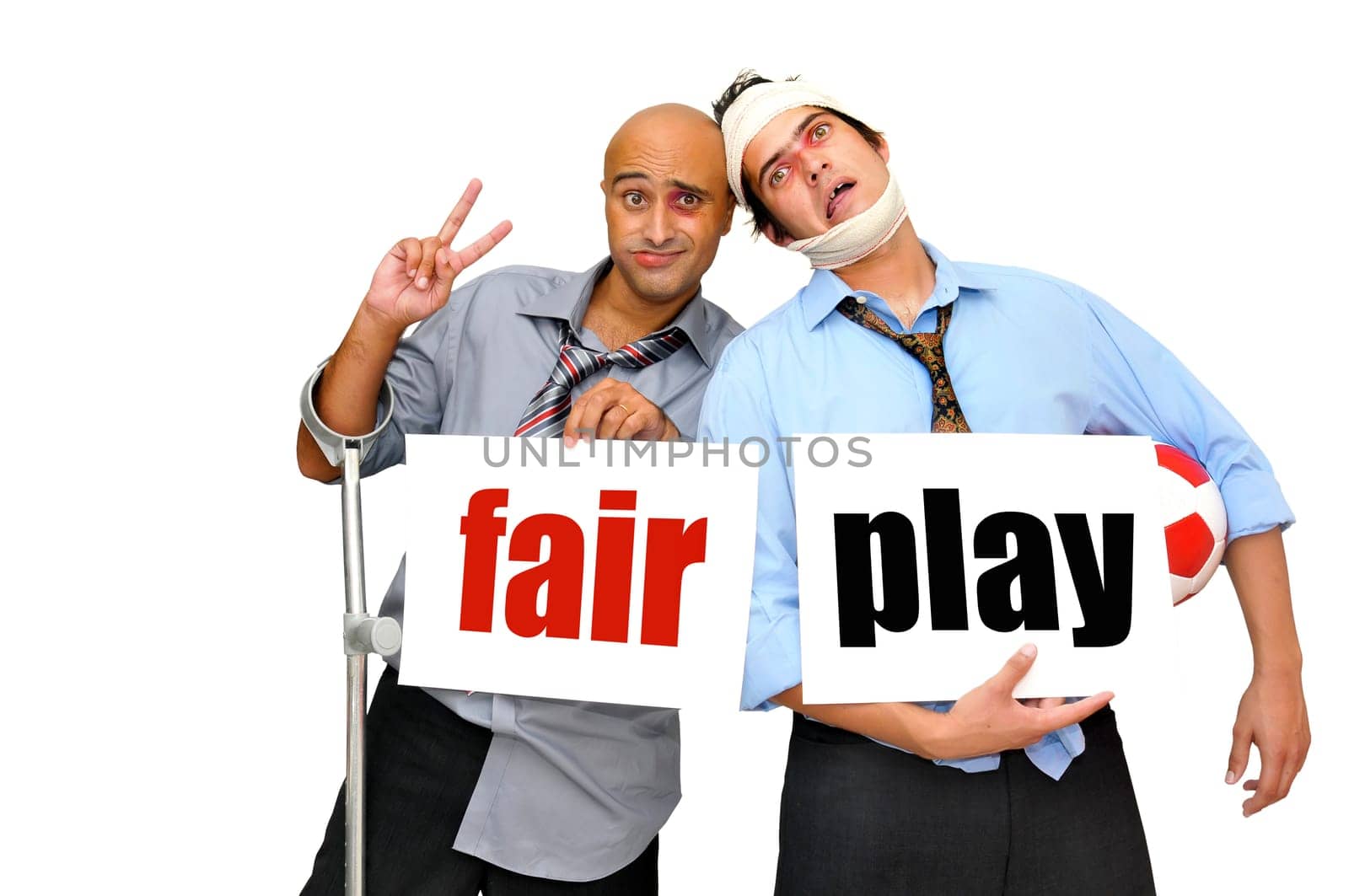 Two badly injured businessmen after a soccer match with cards saying Fair play, isolated in white