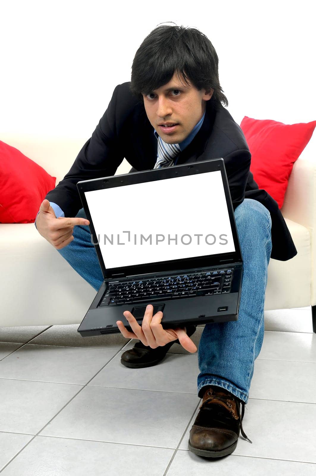 Young bussinessman in a couch with a laptop isolated in white