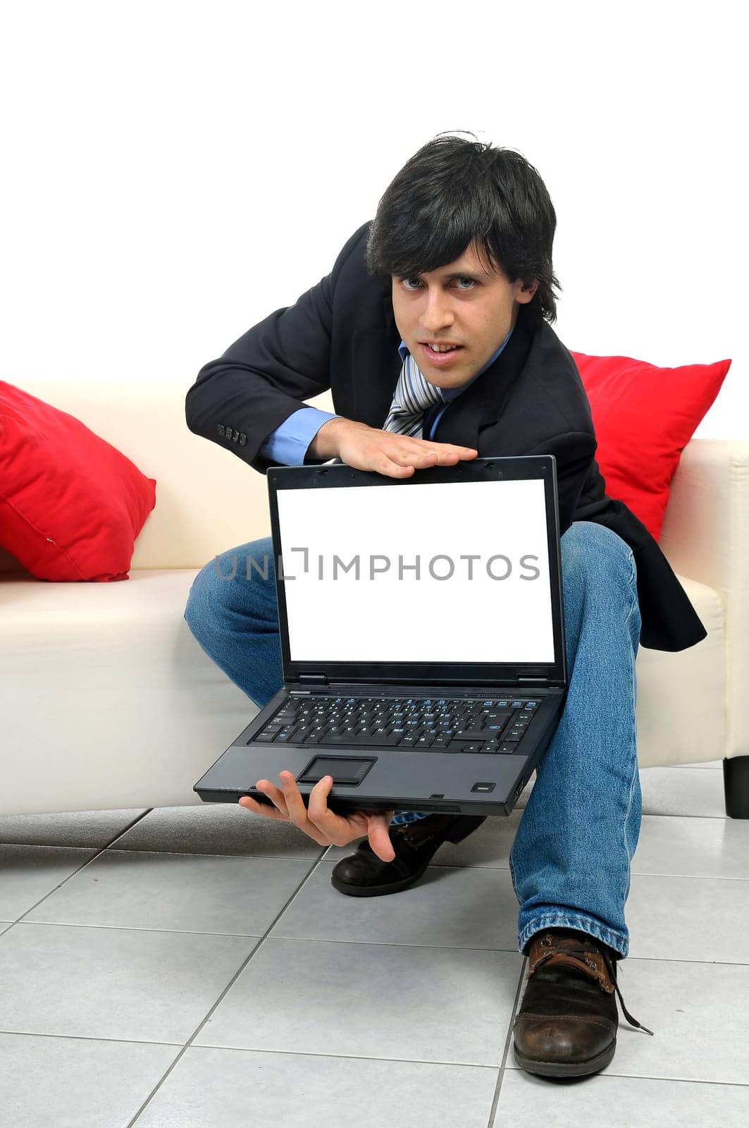 Young bussinessman in a couch with a laptop isolated in white