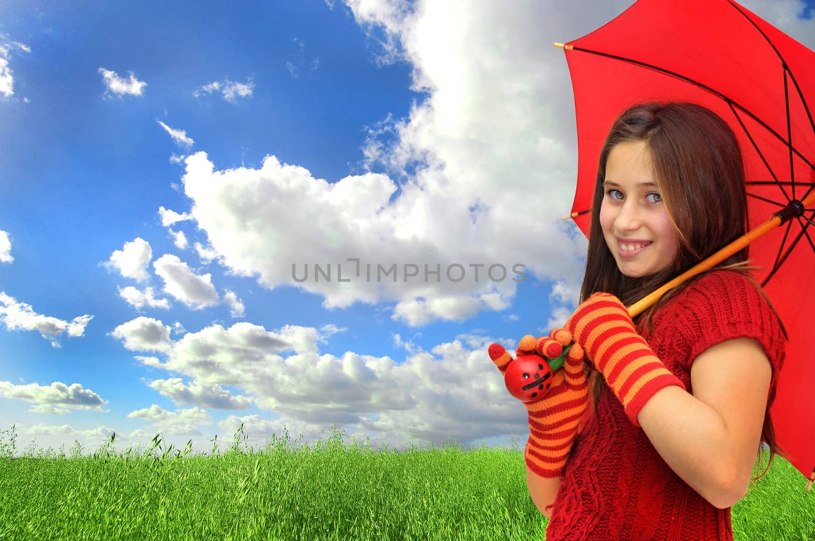 Beautiful girl with umbrella in a beautiful green grass