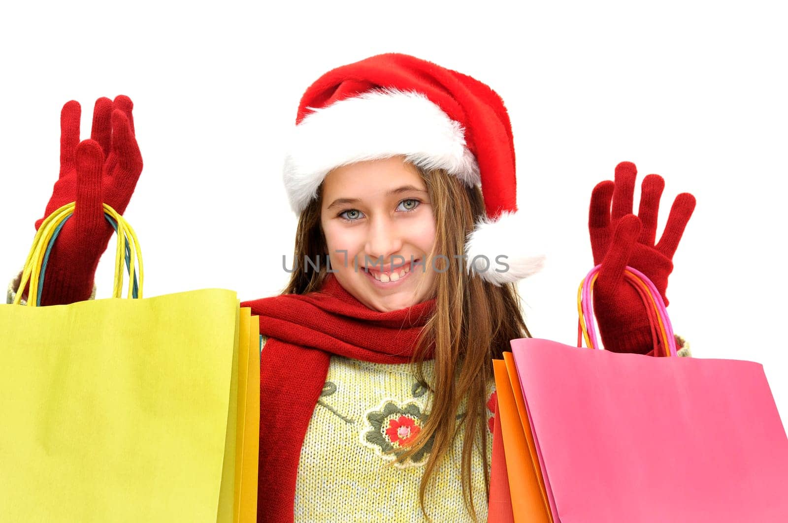 Beautiful young girl with santas hat and shopping bags isolated in white
