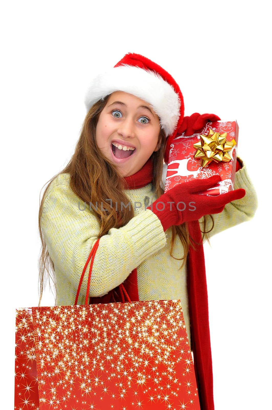 Beautiful young girl with santas hat and shopping bags isolated in white