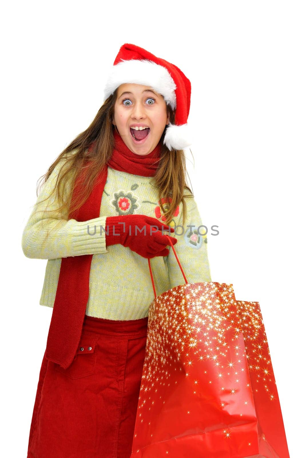 Beautiful young girl with santas hat and shopping bags isolated in white