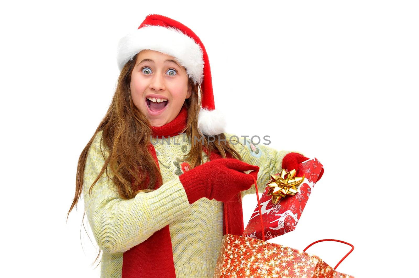 Beautiful young girl with santas hat and shopping bags isolated in white