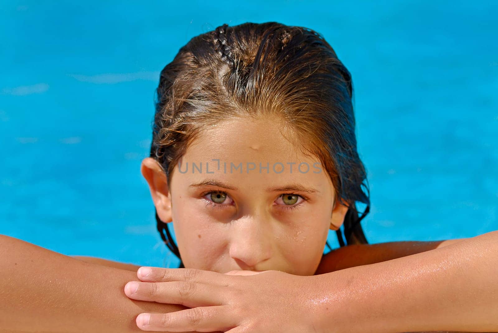 Young girl with green eyes posing in the pool