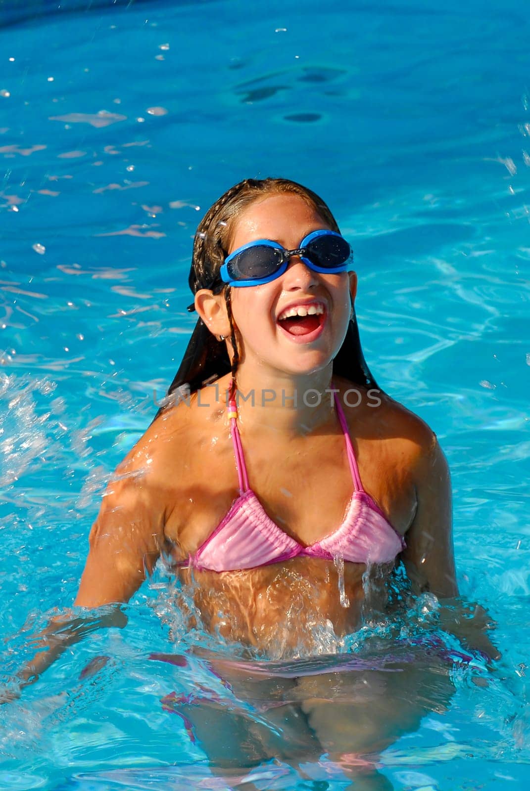 Young girl jumping on a pool