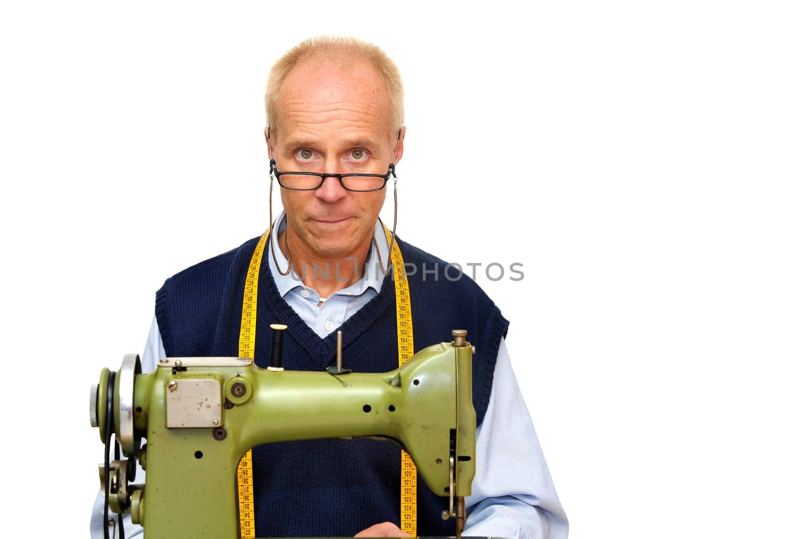 Mature tailor with a sewing machine isolated in white