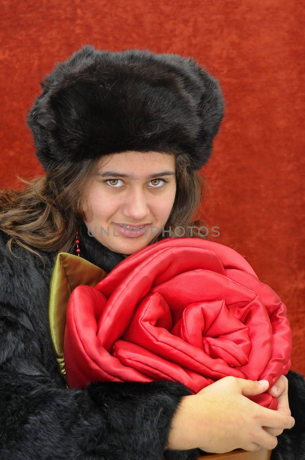 Beautiful girl with roses isolated in a red background