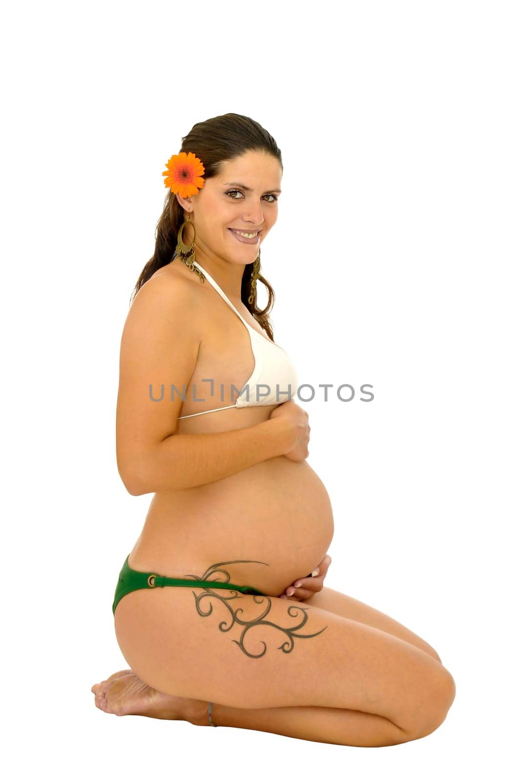 Pregnant woman with tattoo posing in bikini isolated in white