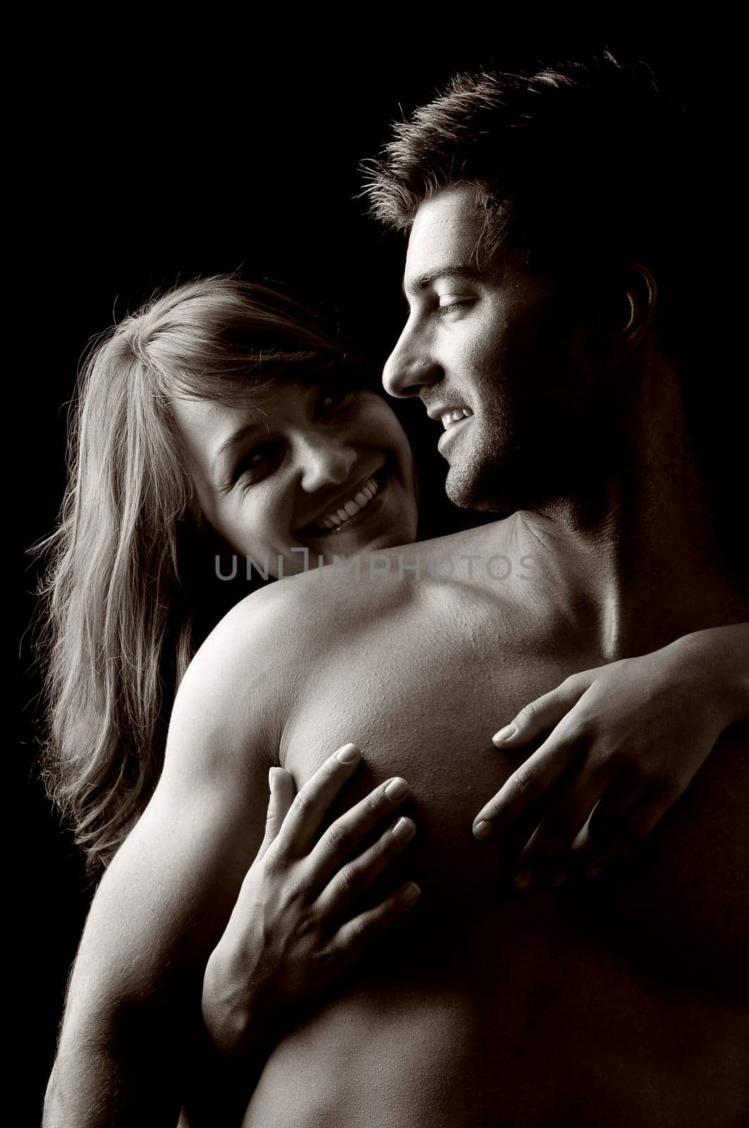 Beautiful fashionable young couple isolated in black