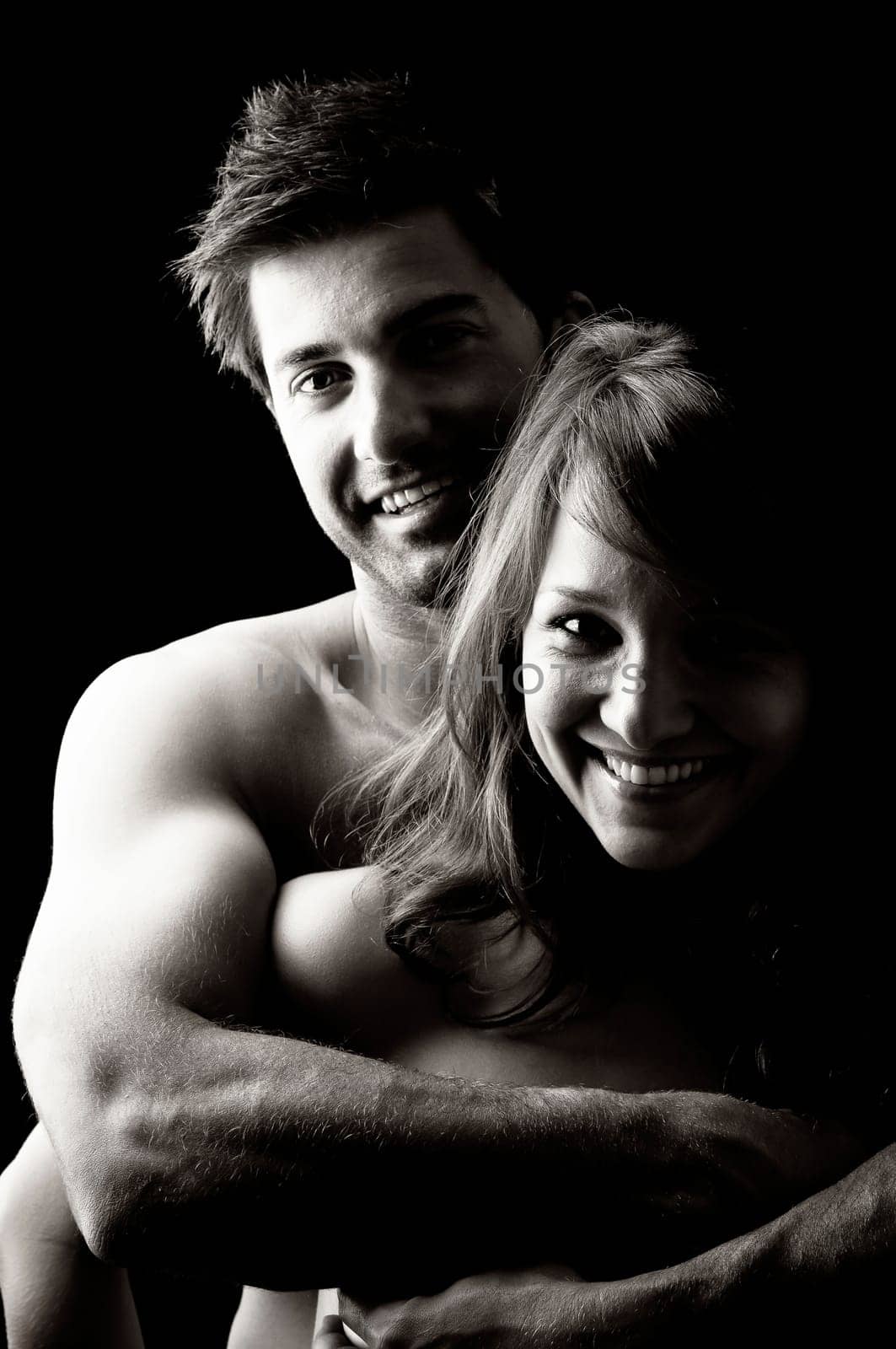 Beautiful fashionable young couple isolated in black