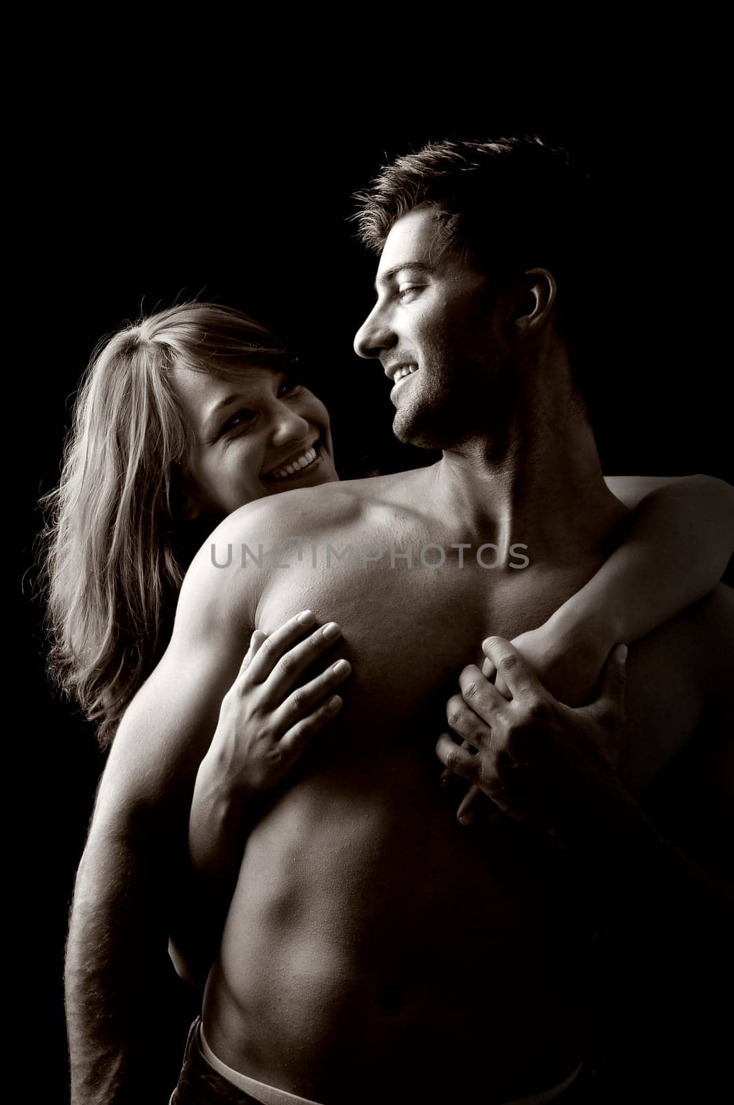 Beautiful fashionable young couple isolated in black