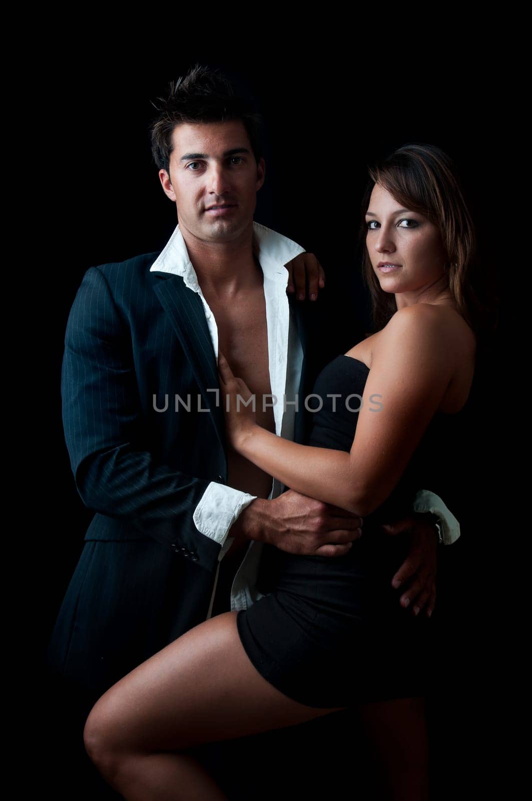 Sexy young couple isolated in black