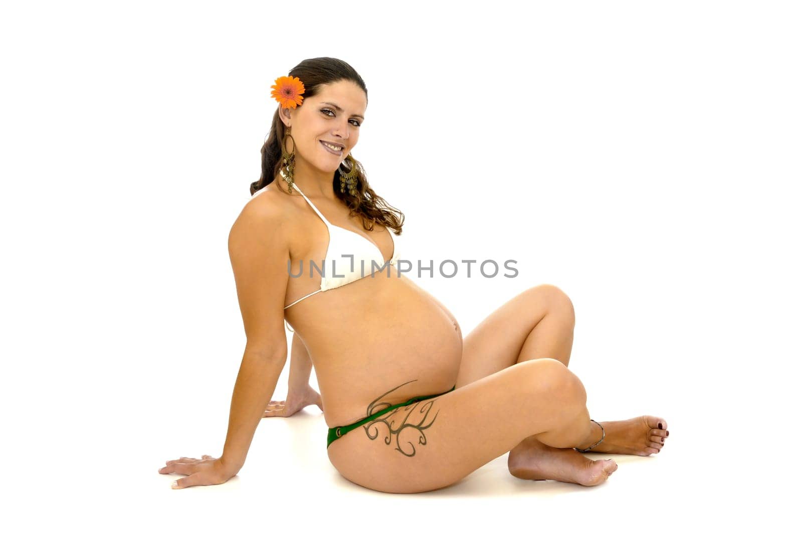 Pregnant woman with tattoo in bikini isolated in white