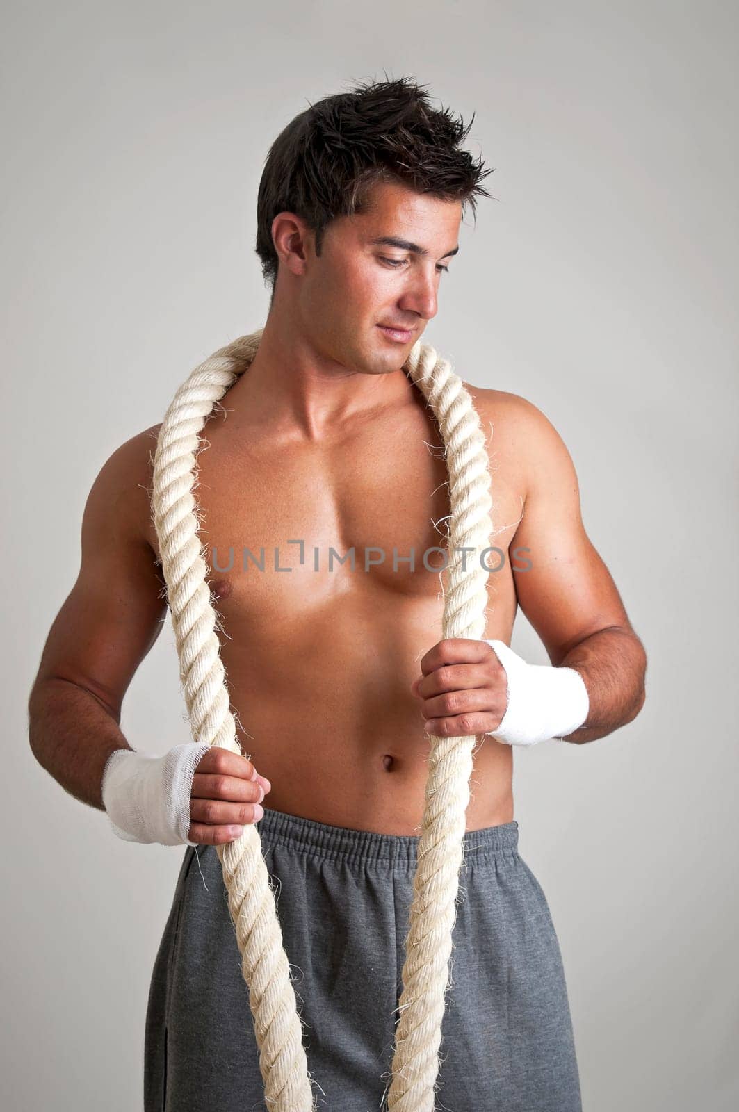 Muscular boxer posing with rope
