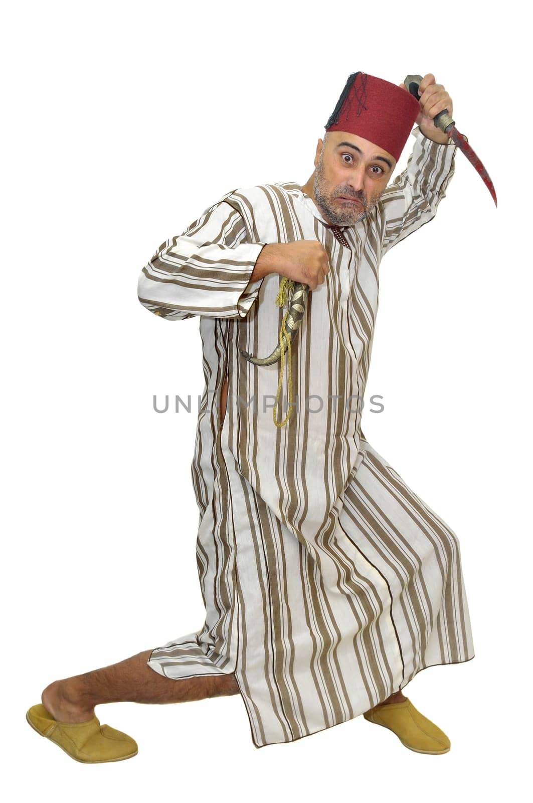 Arabic man with a dagger making funny faces isolated in white