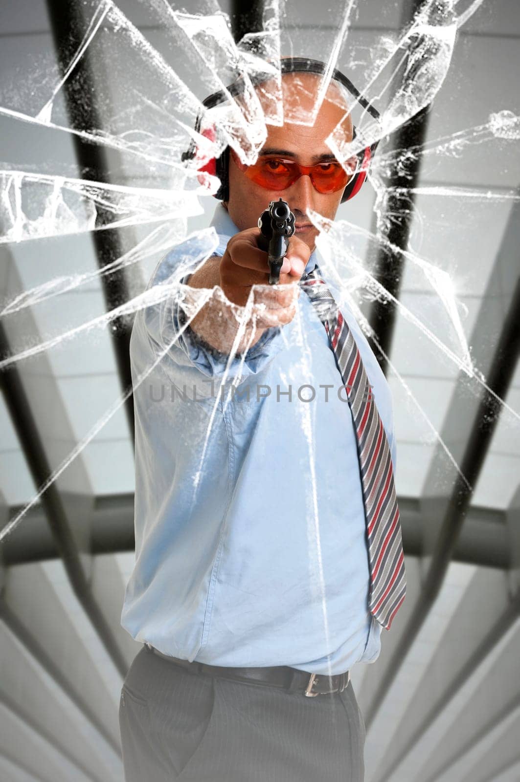 Man with gun shooting through glass window