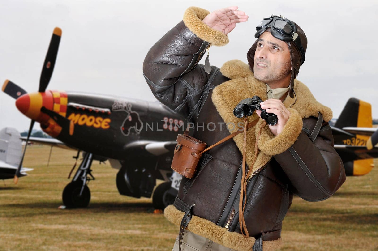 WWII fighter pilot with goggles looking to the sky