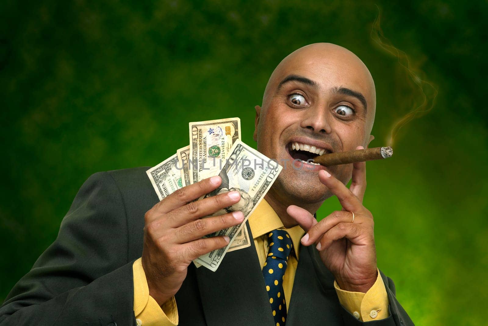 Businessman with money isolated against a dark green background