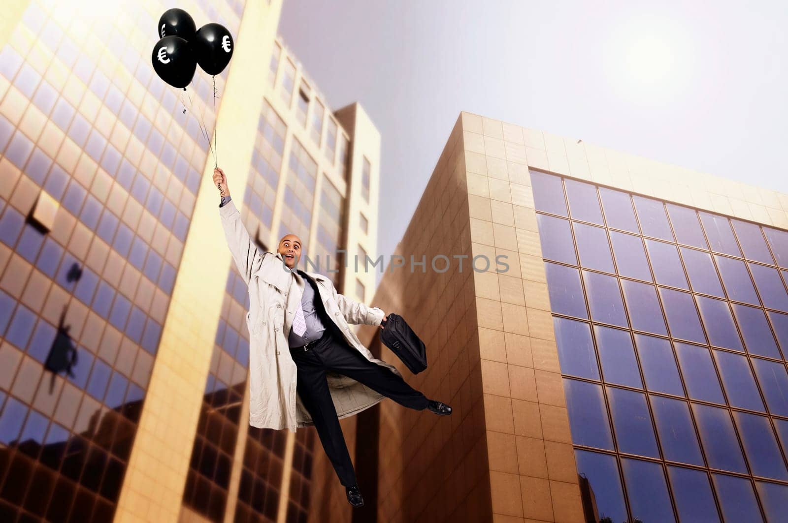Businessman holding a group of black balloons