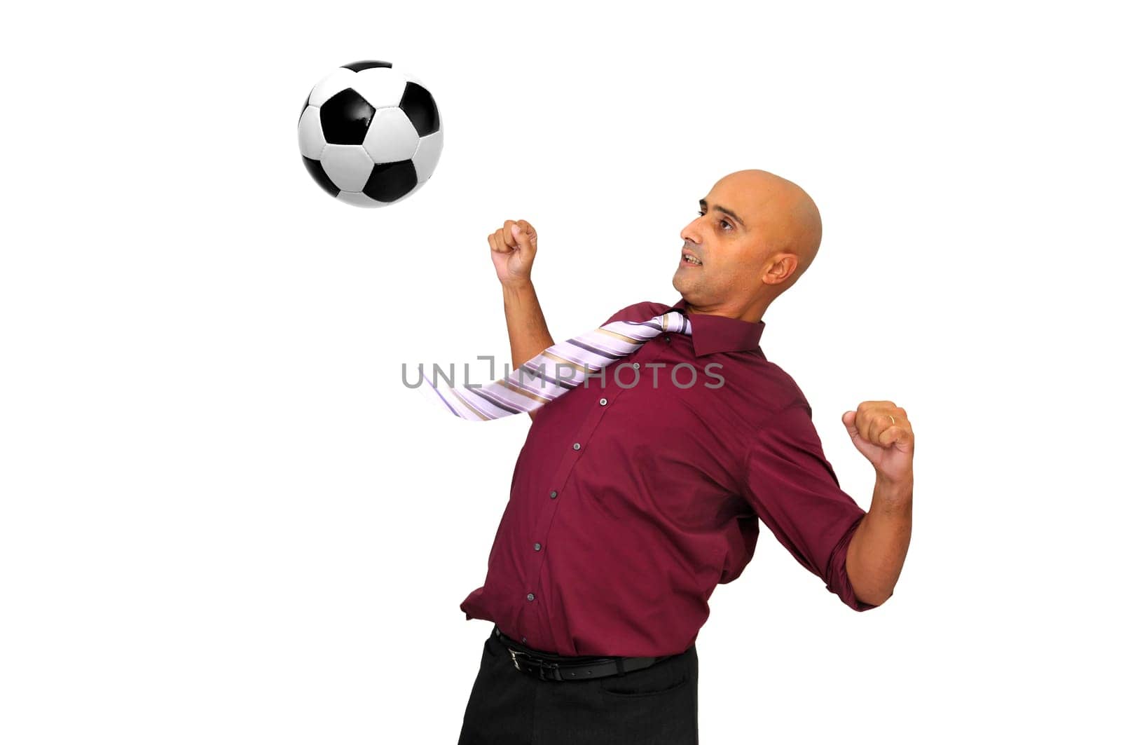 Businessman in a acrobatic pose with a soccer ball isolated in white