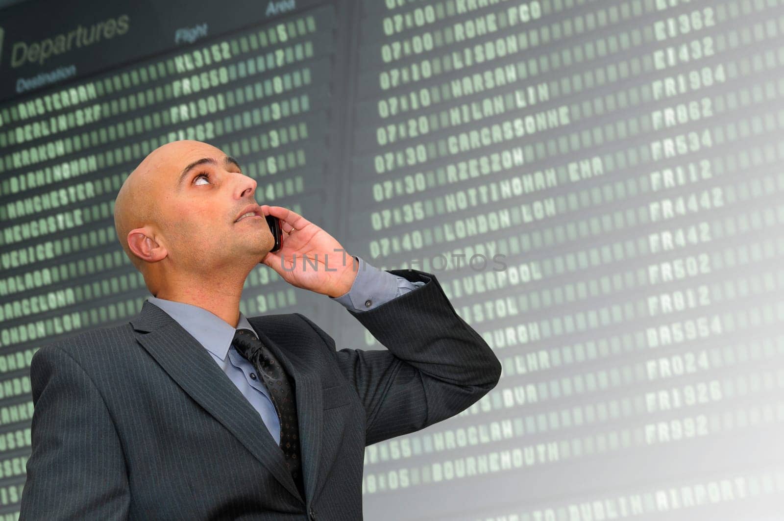 Businessman with cellphone in the airport departures area