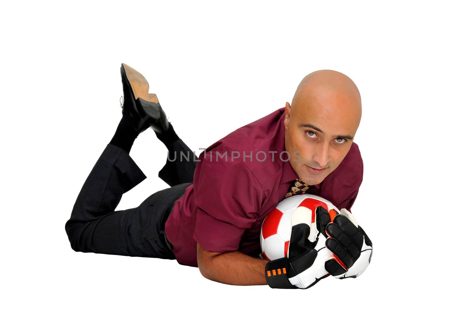 Businessman goalkeeper with gloves and ball in a acrobatic save isolated in white