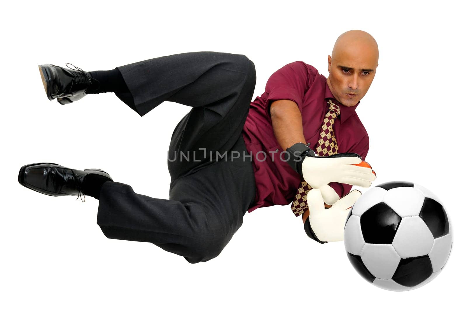 Businessman goalkeeper with gloves and ball in a acrobatic save isolated in white