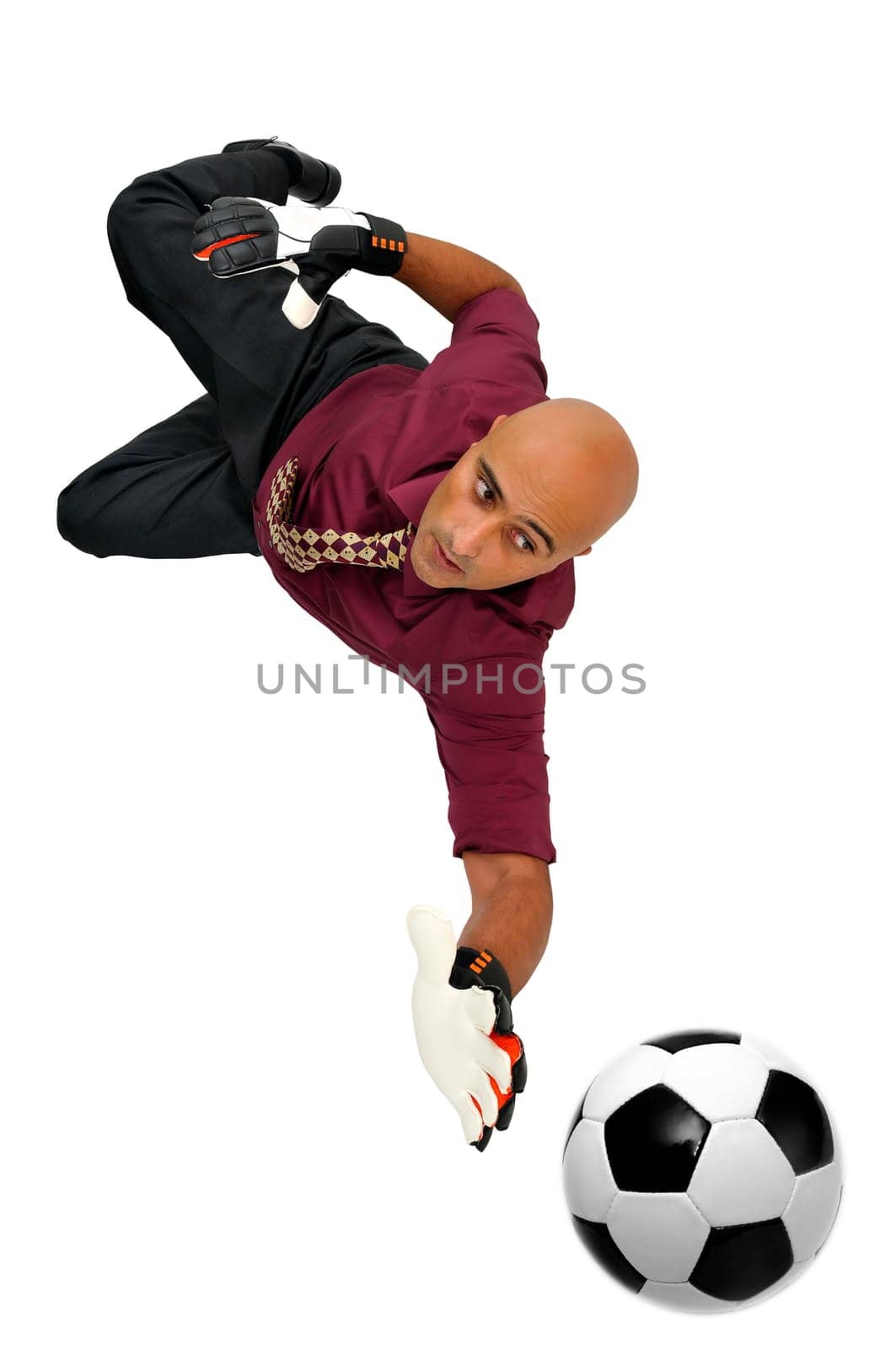 Businessman goalkeeper with gloves and ball in a acrobatic save isolated in white