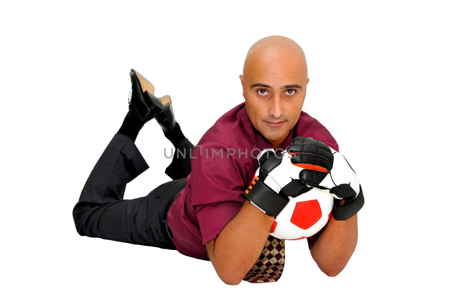 Businessman goalkeeper with gloves and ball in a acrobatic save isolated in white