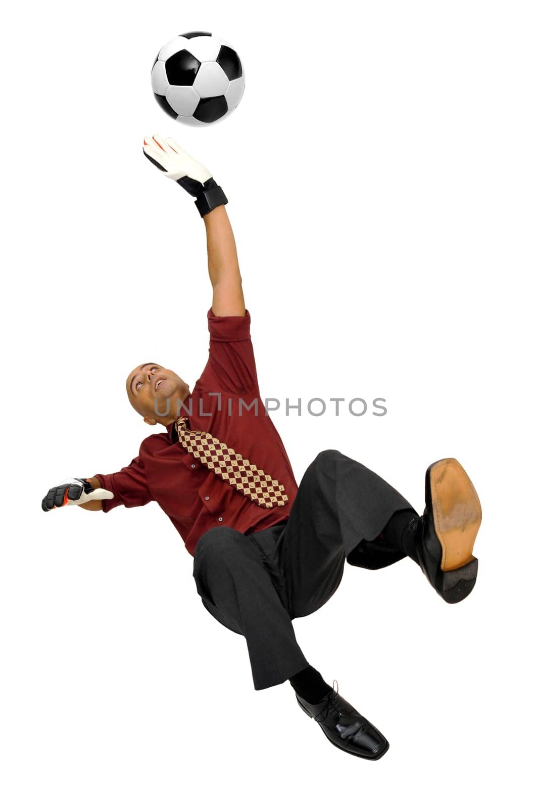 Businessman goalkeeper with gloves and ball in a acrobatic save isolated in white
