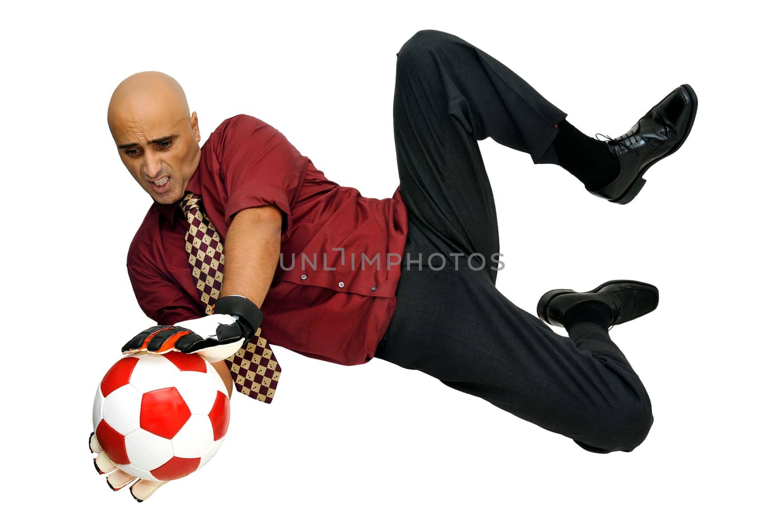 Businessman goalkeeper with gloves and ball in a acrobatic save isolated in white