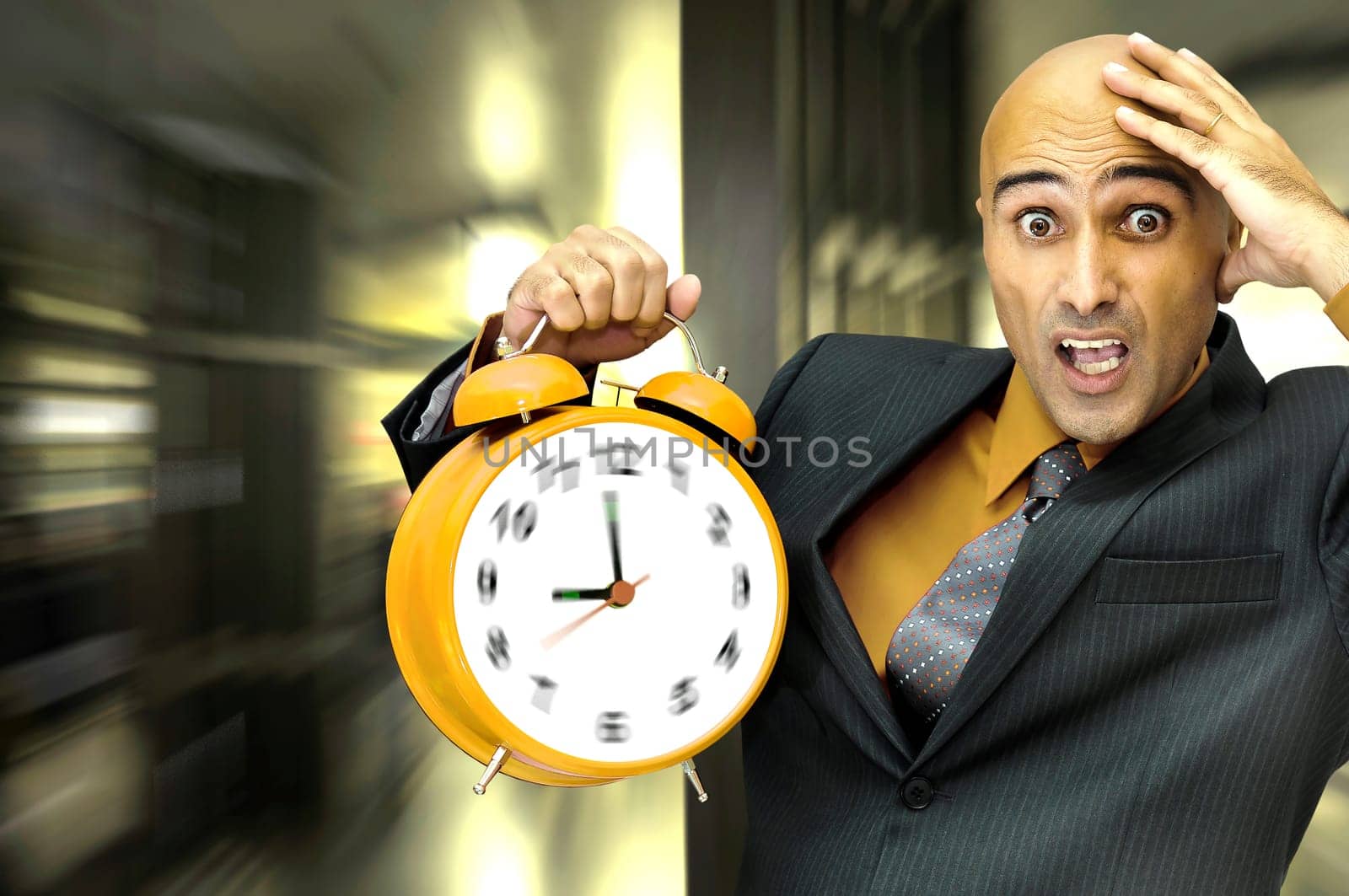 Businessman holding a big alarm clock