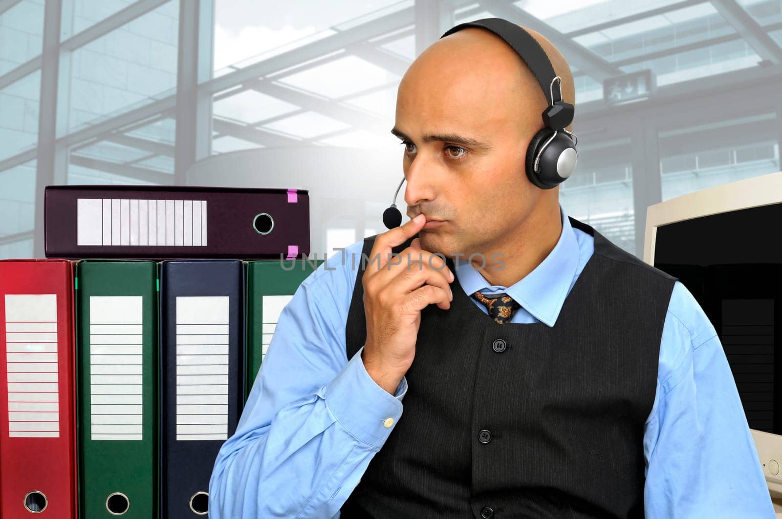 Thinking businessman with headset in the office isolated in white