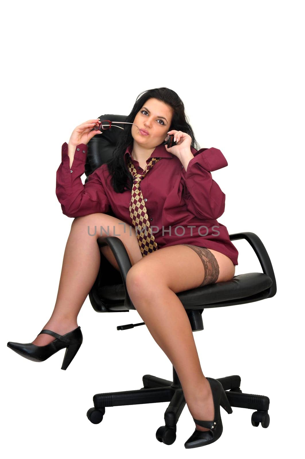 Sexy businesswoman in a chair with tie and stockings isolated in white
