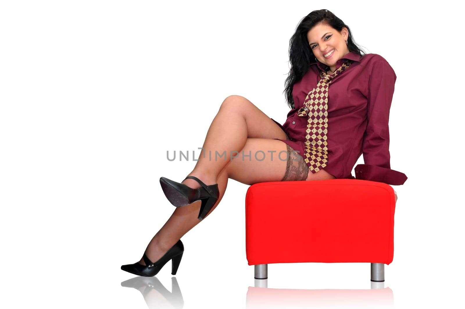 Sexy businesswoman with tie and stockings in a red seat isolated in white