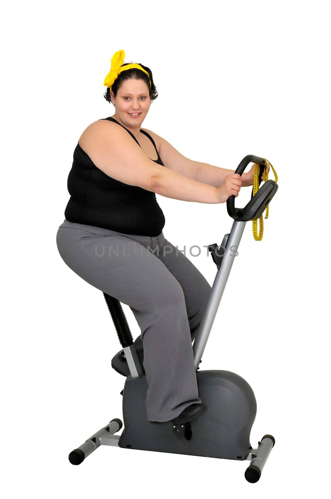 Large girl with fitness bicycle isolated in white