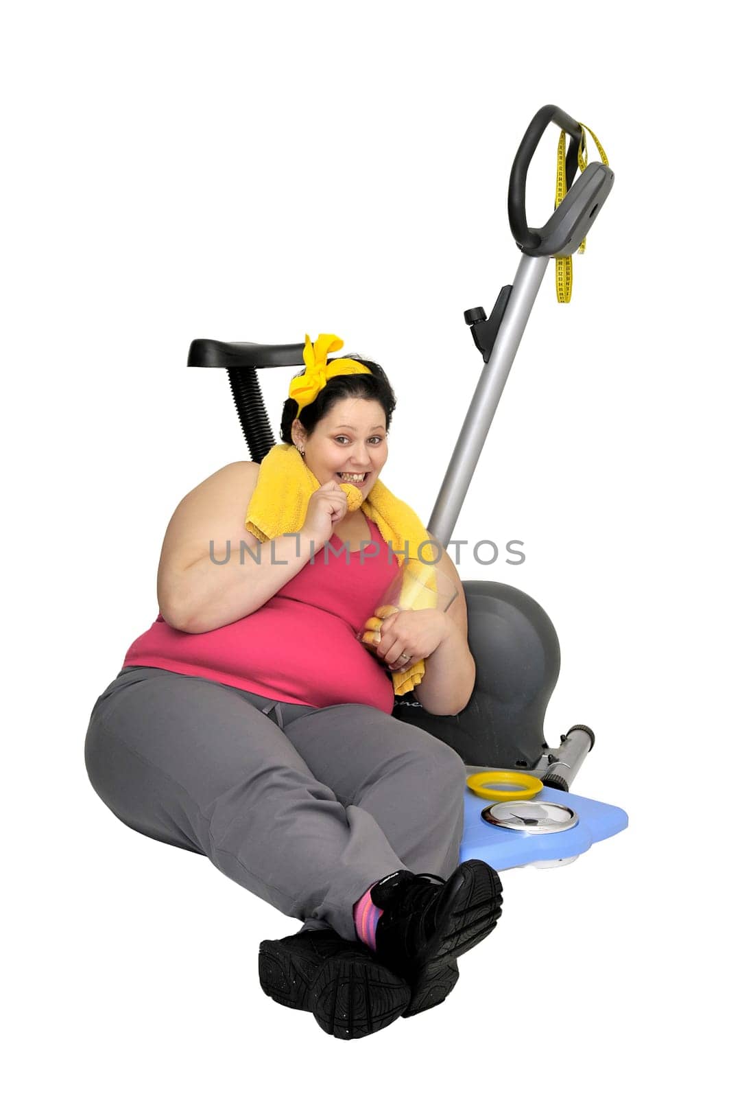 Large girl with fitness bicycle eating cookies isolated in white