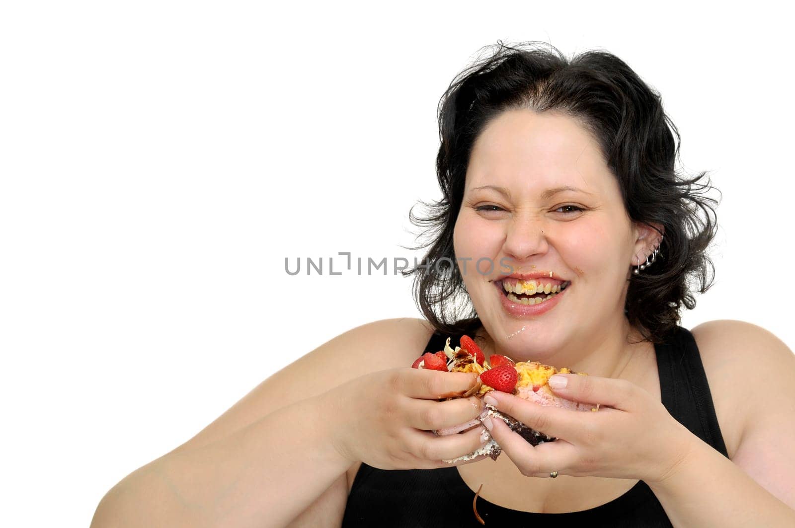 Beautiful large girl laughing with cake remainings in her hand