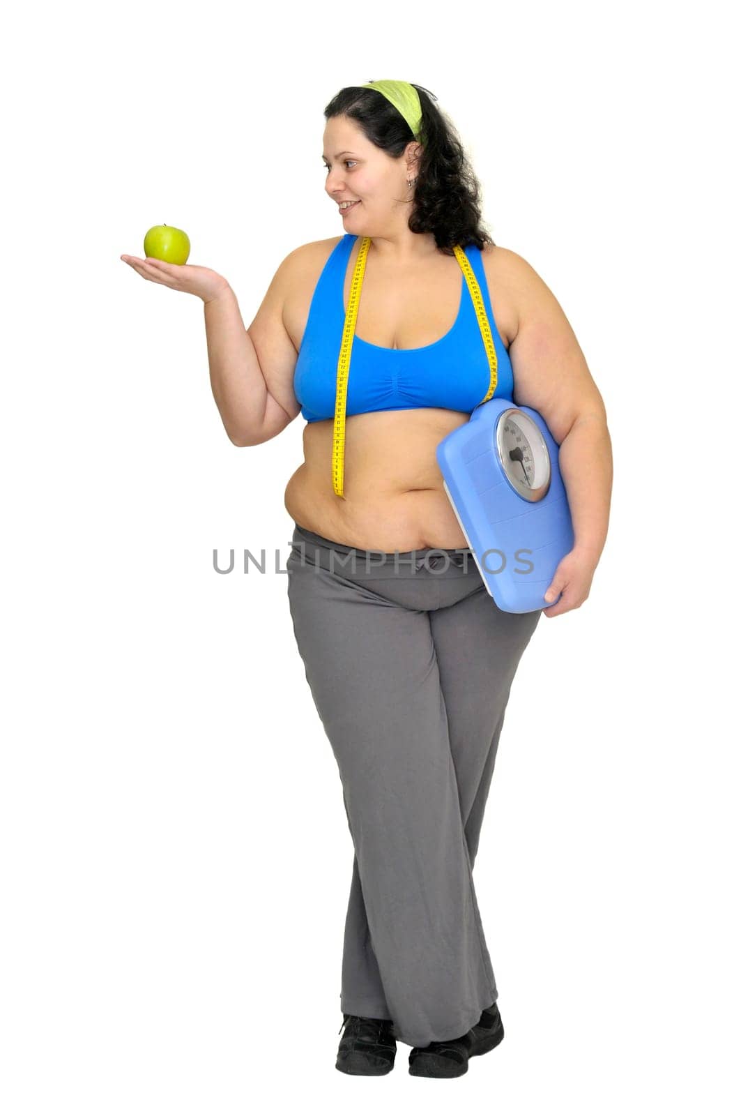 Large girl with apple and weight scale isolated in white