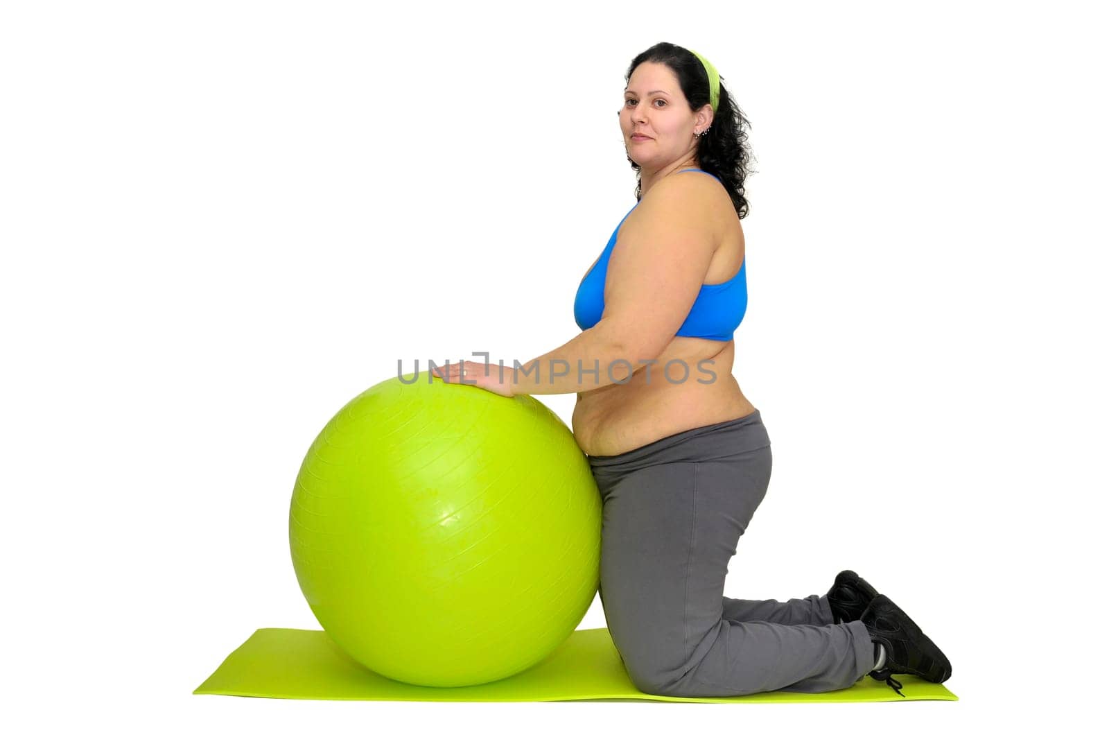 Large girl exercising with big fitness ball isolated in white