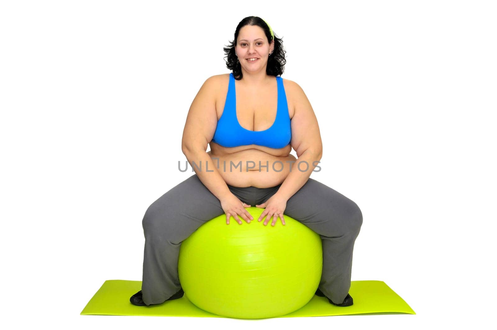 Large girl exercising with big fitness ball isolated in white