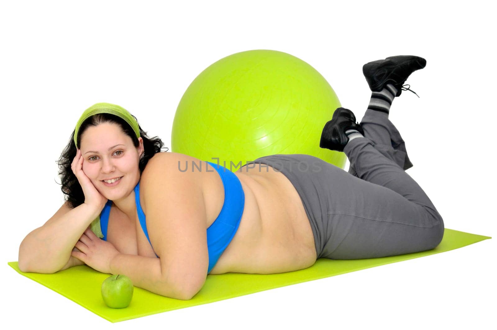 Large girl with an aplle and a fitness ball isolated in white