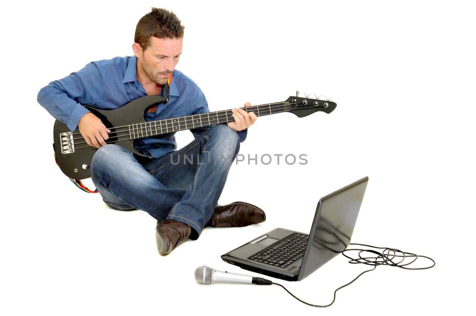 Young man playing guitar with a laptop