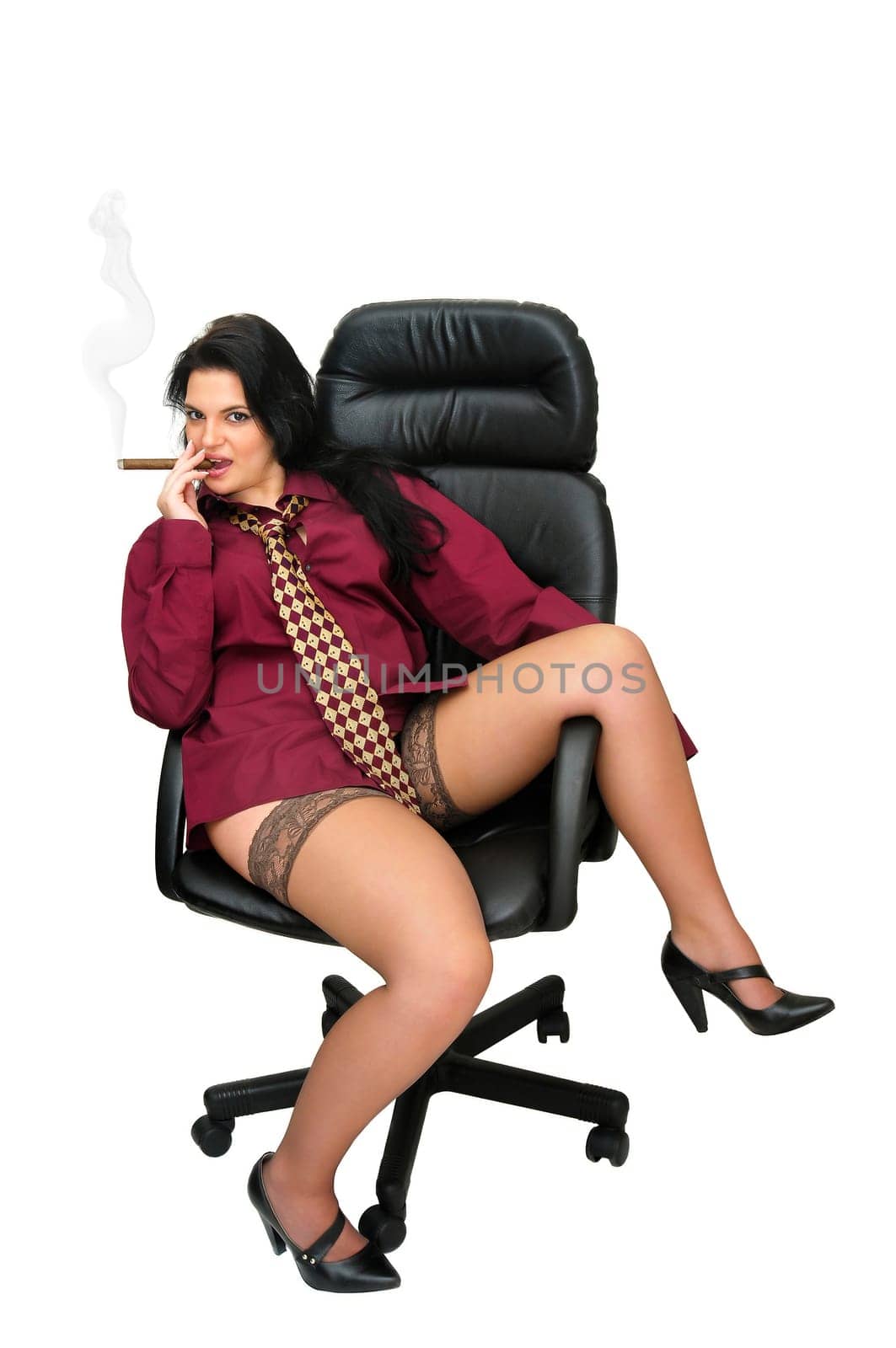 Sexy businesswoman in a chair smoking a cigar isolated in white