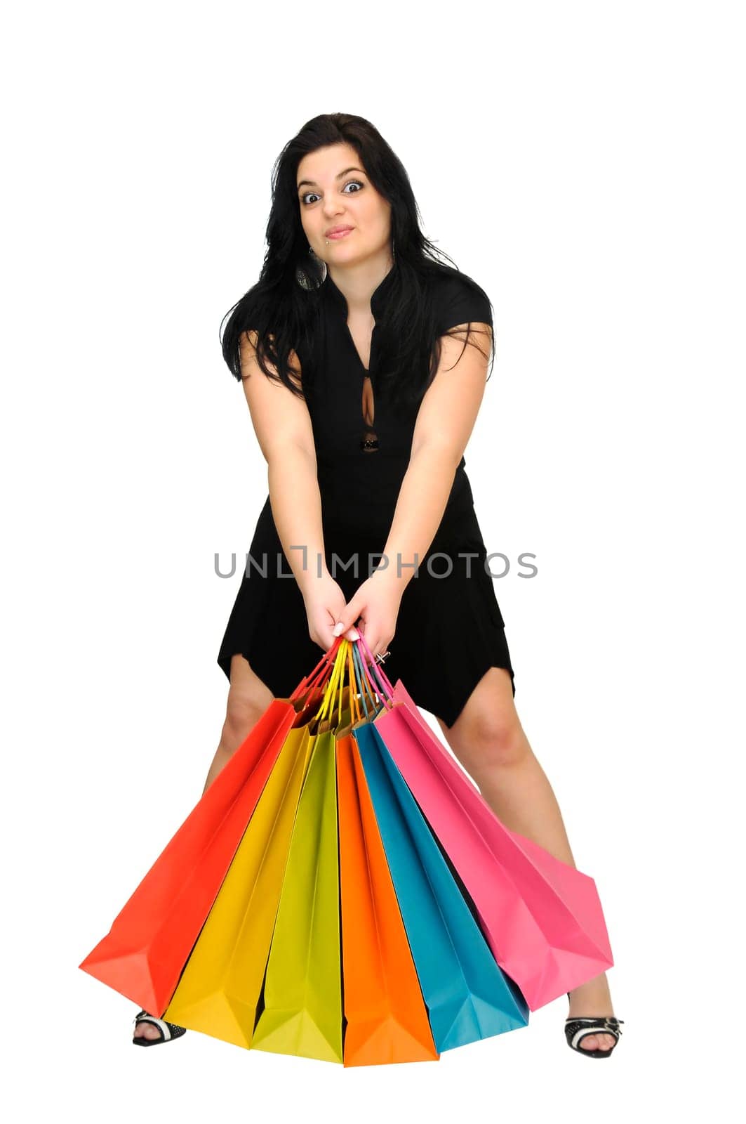 Sexy woman in black dress with colorful bags isolated in white