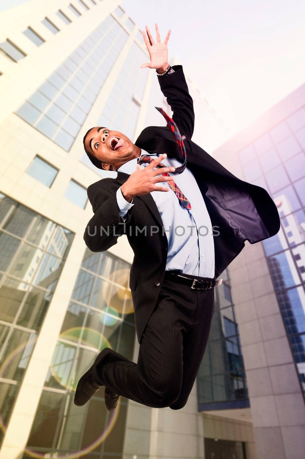 Happy businessman jumping outdoors