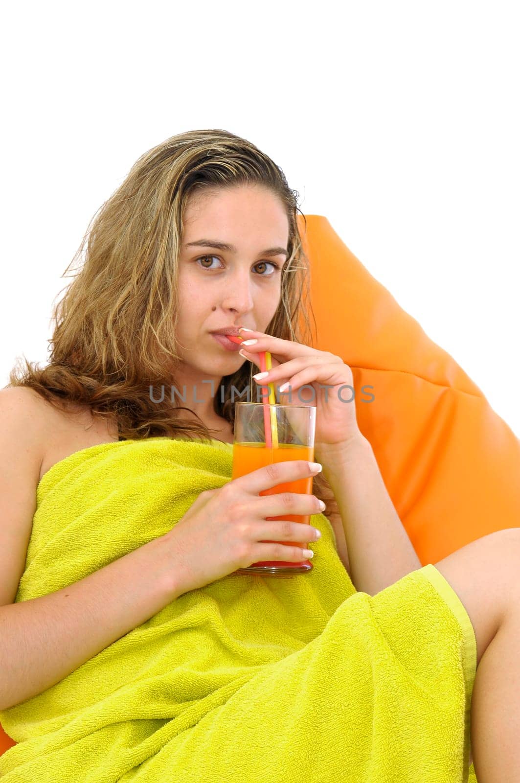 Sexy young girl with a natural juice glass and colorful towel isolated in white